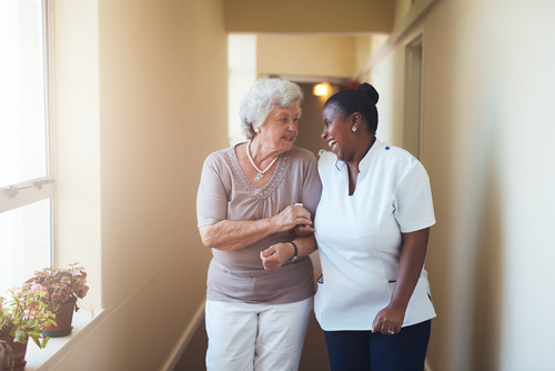 caregiver and senior woman walking together
