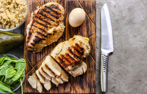 wooden cutting board with chicken breasts