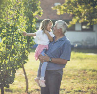 Granddaughter and grandfather spend time in an orchard
