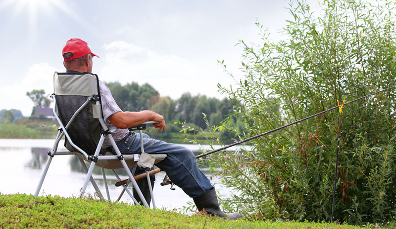 man sitting with fishing pole