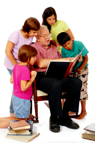 grandfather looking at photo albums with grandchildren