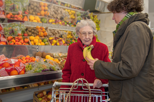 Caregiver helps senior woman while shopping