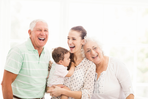 Happy grandparents playing with their grandson at home