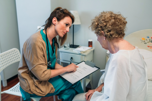 doctor filling out questionnaire with patient