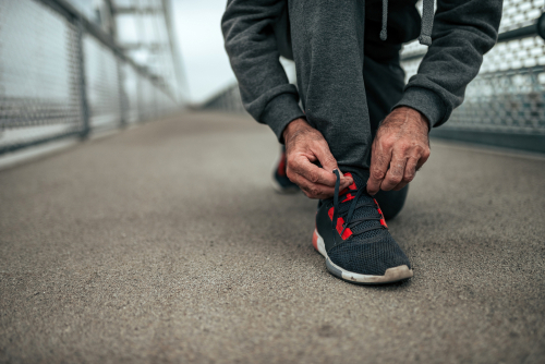 closeup senior tying running shoes