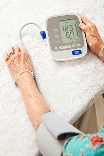 senior woman using blood pressure cuff